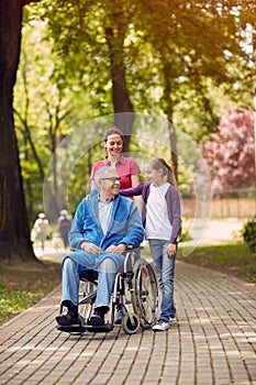 Disabled man in park spending time together with his daughter an