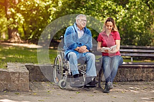 Disabled man in park spending time together with his daughter re