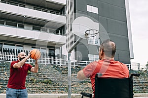 Disabled man playing basketball with a friend