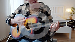 A disabled man is playing the guitar and singing songs professionally