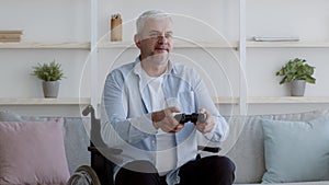 Disabled Man Playing Videogame Sitting In Wheelchair Having Fun Indoors