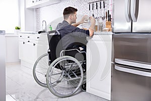Disabled Man Preparing Food In Kitchen