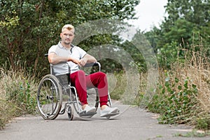 A disabled man sits in a wheelchair on the street. The concept of a wheelchair, disabled person, full life, paralyzed, disabled