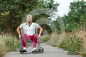 A disabled man sits in a wheelchair on the street. The concept of a wheelchair, disabled person, full life, paralyzed, disabled