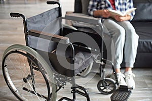 Disabled man sitting near wheelchair alone