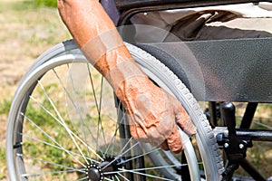 A disabled man is sitting in a wheelchair ,Holds his hands on the wheel. Handicap people Concept