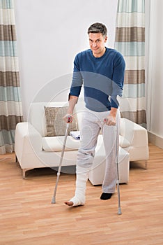 Disabled man using crutches for walking