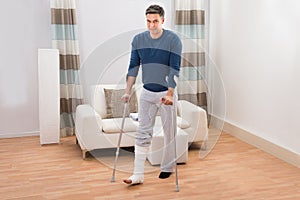 Disabled man using crutches for walking