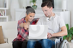 Disabled man using laptop sitting next to girlfriend