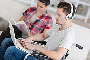 Disabled man using laptop sitting next to girlfriend