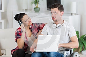 disabled man using laptop sitting next to girlfriend