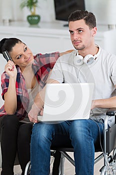 disabled man using laptop sitting next to girlfriend