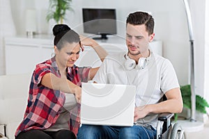 disabled man using laptop sitting next to girlfriend