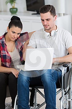 disabled man using laptop sitting next to girlfriend