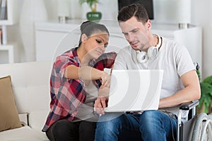disabled man using laptop sitting next to girlfriend