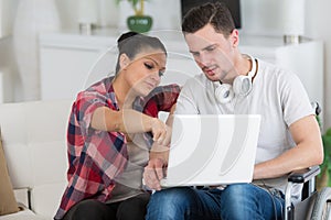 disabled man using laptop sitting next to girlfriend photo