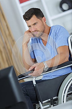 Disabled man watching tv in living room at home