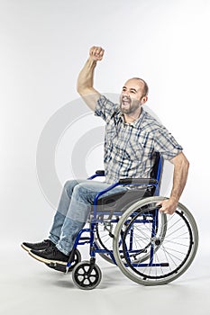 Disabled man on wheelchair with arm raised