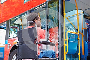 Disabled Man In Wheelchair Boarding Bus