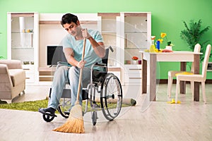 The disabled man on wheelchair cleaning house