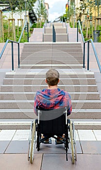 Disabled man in wheelchair in front of stairs