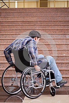 The disabled man on wheelchair having trouble with stairs