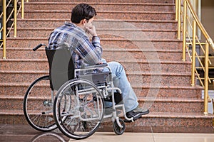 The disabled man on wheelchair having trouble with stairs