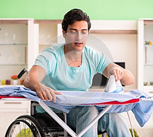 Disabled man on wheelchair ironing clothing