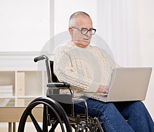 Disabled man in wheelchair on laptop