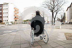 Invalidní muž na invalidní vozík kouká na ulice 