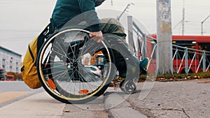 Disabled man in wheelchair makes attempt to climb a step - another people help him