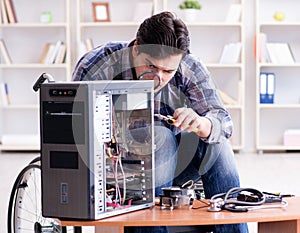 Disabled man on wheelchair repairing computer