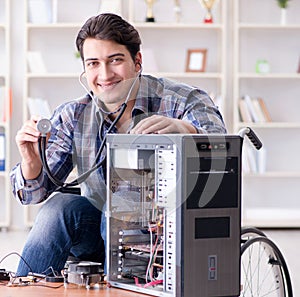 Disabled man on wheelchair repairing computer