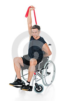 Disabled man on wheelchair stretching with resistance band