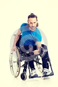 Disabled man in wheelchair train with bar-bell