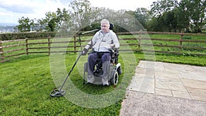 Disabled man Wheelchair user metal detecting for coins field