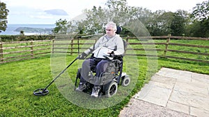 Disabled man Wheelchair user metal detecting for coins field