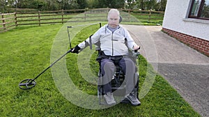 Disabled man Wheelchair user metal detecting for coins field