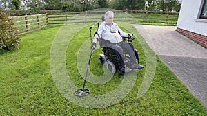 Disabled man Wheelchair user metal detecting for coins field