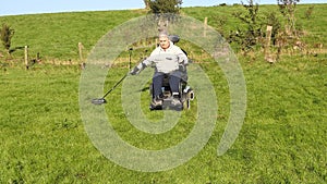 Disabled man Wheelchair user metal detecting for coins field