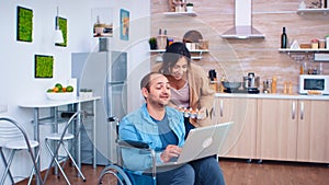 Disabled man in wheelchair using laptop