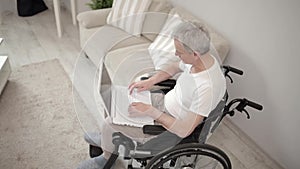 Disabled man in wheelchair using laptop at hospital