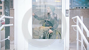 Disabled man in wheelchair using a special elevator for disabled people to get up from the underground crossing