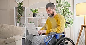 Disabled man on wheelchair working with laptop