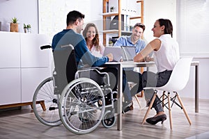 Disabled Manager Sitting With His Colleagues