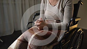 Disabled nervous female clenching hands, feeling lonely and helpless, wheelchair