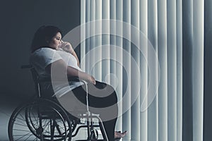 Disabled obese woman looks pensive