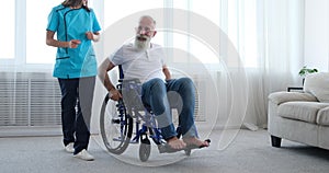 Disabled old man refusing female nurse for help and pushing self on wheelchair