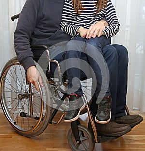 Disabled parent in a wheelchair with his little daughter