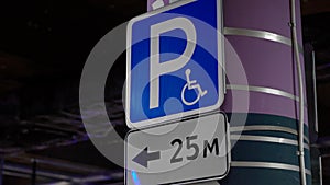 Disabled parking sign. Underground parking. Cars parked in a shopping center.